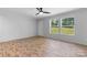 Bright, open living room with wood flooring, large windows offering a view, and a modern ceiling fan for added comfort at 110 Lambert Ln, Statesville, NC 28677