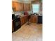Kitchen featuring wooden cabinets, tile flooring, and black appliances at 1313 Lower Dallas Hwy Hwy, Dallas, NC 28034