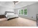 Bright bedroom with tray ceiling, large window, and neutral walls and carpet at 139 Forest Walk Way, Mooresville, NC 28115