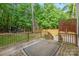 Wooden deck with a railing overlooking a lush, green backyard with mature trees at 139 Forest Walk Way, Mooresville, NC 28115