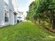 This expansive backyard offers lush lawn, mature trees, and a patio with outdoor furniture, perfect for outdoor activities at 1564 Trippett Nw St, Concord, NC 28027