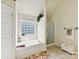 Bright bathroom featuring soaking tub, glass block window and stand up shower at 1564 Trippett Nw St, Concord, NC 28027