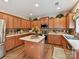 Well-equipped kitchen featuring wood cabinets, granite countertops, stainless steel appliances, and a center island at 1564 Trippett Nw St, Concord, NC 28027