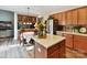 Open concept kitchen with wood cabinets, granite countertops, stainless steel appliances, and an adjacent dining area at 1564 Trippett Nw St, Concord, NC 28027