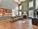 Bright, open living room with high ceilings, a fireplace, large windows, and an adjacent eat-in kitchen at 1564 Trippett Nw St, Concord, NC 28027
