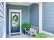 Inviting front porch features a bench, potted plant, and a wreath on the blue front door at 1636 Red Leaf Dr, Fort Mill, SC 29715