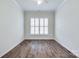 An empty room shows laminate flooring and white shutters on the large window at 1636 Red Leaf Dr, Fort Mill, SC 29715