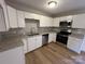 Modern kitchen featuring white cabinets, granite countertops, and stainless steel appliances at 1820 Wendover Dr, Lancaster, SC 29720