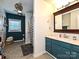 Bathroom featuring double sinks, a framed mirror, and blue cabinets at 202 Cameron Dr, Kings Mountain, NC 28086