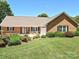 Charming brick home featuring manicured lawn, beautiful landscaping, and an attached two-car garage at 202 Cameron Dr, Kings Mountain, NC 28086