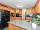 A traditional kitchen features granite counters, wooden cabinets, and modern black appliances at 202 Cameron Dr, Kings Mountain, NC 28086