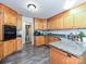 A well lit kitchen features granite countertops, wooden cabinets, and modern flooring at 202 Cameron Dr, Kings Mountain, NC 28086