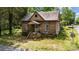 Charming brick home with gabled roof, front porch, and overgrown landscaping at 203 E College St, Star, NC 27356