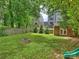Backyard features a fire pit, play area, and mature trees, creating a park-like setting at 2222 Wilmore Dr, Charlotte, NC 28203