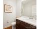 Neat half bathroom with a modern vanity, decorative accents, and hardwood floors at 2222 Wilmore Dr, Charlotte, NC 28203