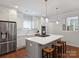 Modern kitchen with a gray island and barstool seating, white cabinets, and stainless steel appliances at 2222 Wilmore Dr, Charlotte, NC 28203