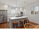 Bright, modern kitchen featuring a gray island with seating, stainless steel appliances, and white cabinets at 2222 Wilmore Dr, Charlotte, NC 28203