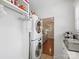 Functional laundry room featuring stacked washer/dryer, built-in shelving, and convenient access to the kitchen at 2222 Wilmore Dr, Charlotte, NC 28203