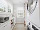 Bright laundry room boasting modern washer/dryer, ample counter space, and convenient storage shelves at 2222 Wilmore Dr, Charlotte, NC 28203