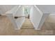 Carpeted staircase leading upstairs, featuring white banisters and natural light from a window at 2222 Wilmore Dr, Charlotte, NC 28203