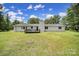 Back exterior view featuring a white painted brick home, deck, chimney, and expansive backyard at 263 Fairway Cir, Rock Hill, SC 29730