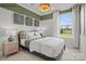 A nicely decorated bedroom with a queen bed, green accent wall and a large window at 2658 Headwind Ct # 245, Belmont, NC 28012