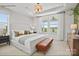 The main bedroom features a large window and an off-white bed topped with decorative pillows and bench at 2658 Headwind Ct # 245, Belmont, NC 28012