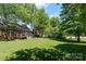Large backyard featuring a brick house, a deck, and mature trees at 3124 17Th Street Ne Ln, Hickory, NC 28601