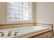 Relaxing bathroom with a soaking tub and tiled surround under a glass block window at 3124 17Th Street Ne Ln, Hickory, NC 28601