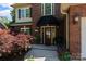 Inviting home entrance featuring a covered doorway, elegant landscaping, and a cozy bench at 3124 17Th Street Ne Ln, Hickory, NC 28601