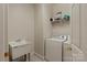 Bright laundry room featuring a utility sink, washer, dryer, and overhead storage shelf at 3124 17Th Street Ne Ln, Hickory, NC 28601