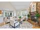 Sunlit living room featuring a brick fireplace, wood floors and an open floorplan at 3124 17Th Street Ne Ln, Hickory, NC 28601
