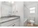 Bright bathroom features a granite countertop, white cabinets, and a tub with shower at 314 Adams St, Salisbury, NC 28144