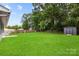 Spacious backyard with lush green grass, a storage shed, and a wooden fence at 316 Fulton St, Kings Mountain, NC 28086