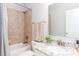 Well-lit bathroom featuring granite vanity, and shower-tub with decorative tile surround at 324 Squash Harvest Ct, Matthews, NC 28104