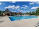 Beautiful community pool area with ample seating and covered lounge spaces on a sunny day with fluffy clouds at 324 Squash Harvest Ct, Matthews, NC 28104