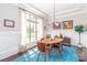 Elegant dining room with large windows, hardwood floors, stylish chandelier, and neutral wall colors at 324 Squash Harvest Ct, Matthews, NC 28104