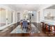 Open dining space with hardwood floors, stylish furniture, and access to a kitchen bar and staircase at 324 Squash Harvest Ct, Matthews, NC 28104
