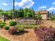 Elegant stone entrance sign to the Atherton community, adorned with lush greenery and colorful flowers at 324 Squash Harvest Ct, Matthews, NC 28104