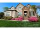 Charming brick home with manicured lawn and vibrant pink azaleas, creating a welcoming curb appeal at 324 Squash Harvest Ct, Matthews, NC 28104