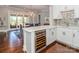 Charming kitchen with white cabinets, backsplash and wine cooler with access to dining area and outdoor patio at 324 Squash Harvest Ct, Matthews, NC 28104