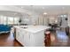 Open kitchen featuring a large white island, modern appliances, and seamless flow into the dining and living spaces at 324 Squash Harvest Ct, Matthews, NC 28104