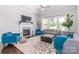 Bright living room featuring a fireplace, large windows with backyard views and a comfortable seating arrangement at 324 Squash Harvest Ct, Matthews, NC 28104