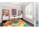 Bright home office featuring a large window, stylish desk, and colorful floral rug on hardwood floor at 324 Squash Harvest Ct, Matthews, NC 28104