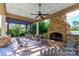 Cozy outdoor patio with a stone fireplace and comfortable seating, ideal for gatherings and enjoying the outdoors at 324 Squash Harvest Ct, Matthews, NC 28104
