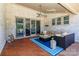 Cozy covered outdoor living area with a brick wall, comfortable seating and beautiful wood flooring at 324 Squash Harvest Ct, Matthews, NC 28104