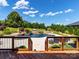 Backyard featuring a large in-ground pool with stone accents and professionally landscaped greenery at 324 Squash Harvest Ct, Matthews, NC 28104