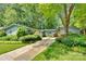 Exterior of charming home with mature trees, lush landscaping, and long driveway at 331 Glen Oaks Rd, Charlotte, NC 28270
