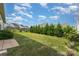 Serene backyard with green lawn, black metal fence, and lush trees against the backdrop of a partly cloudy sky at 333 Dudley Dr, Fort Mill, SC 29715