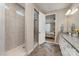 Bright bathroom featuring a tiled shower, granite vanity, and open doorway to the main bedroom at 333 Dudley Dr, Fort Mill, SC 29715